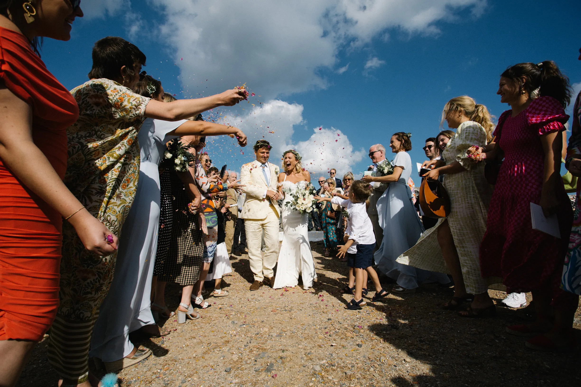 Confetti thrown over the newlyweds under a blue sky — Tas & Georgia wedding gallery